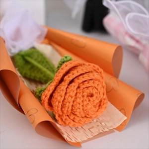 Handmade crochet orange rose bouquet with knitted green leaves in decorative heart paper