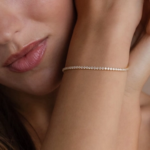 Close-up of a gold-plated tennis bracelet with sparkling round-cut cubic zirconia stones