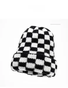 Close-up of thick checkered knit beanie showing the black and white woven texture
