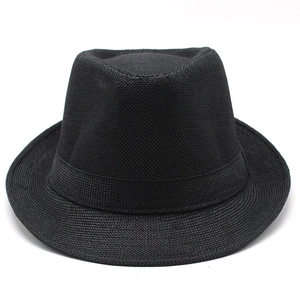 Gros plan sur un chapeau fedora noir tressé montrant la texture et le ruban