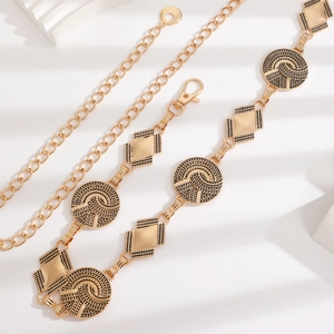 Detail of bohemian gold metal waist chain with embossed circular and diamond-shaped links
