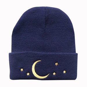 Navy blue knitted beanie featuring gold star and moon embroidery in a ribbed warm fabric