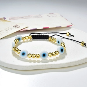 Handmade woven Evil Eye bead bracelet with blue glass eyes and golden copper beads