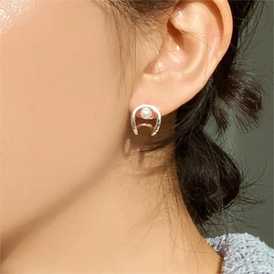 Elegant 925 sterling silver horseshoe stud earrings with white pearl on female model