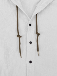 Detail view of white linen hooded shirt showing brown drawstring and dark buttons texture