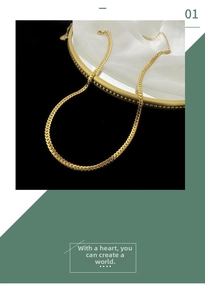 Detailed macro view of flat gold-plated herringbone snake chain with lobster clasp and extender