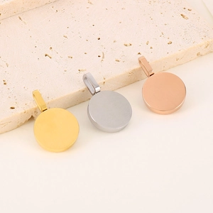 Three minimalist round metal pendants in gold, silver, and rose gold on a stone plate