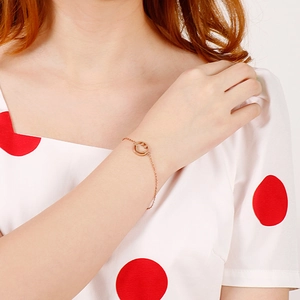 Detail of rose gold smile pendant bracelet worn on wrist for trendy summer styling