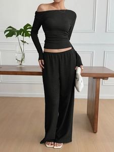 Women's 2-piece black textured set with long sleeve off-shoulder top and wide-leg trousers