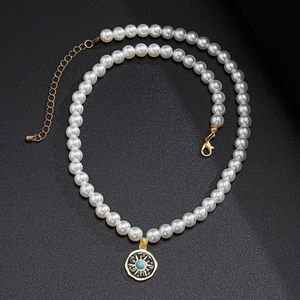 Hip hop pearl necklace with golden sun pendant and turquoise stone on black background
