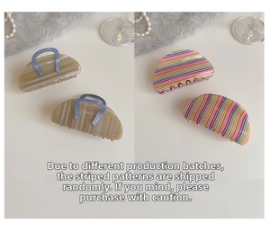 Detail of acetate cherry hair claws in beige marble and colorful striped patterns