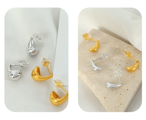 Macro shot of minimalist water drop earrings in gold and silver finish on stone