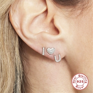 Detail of 925 sterling silver I love U stud earrings with sparkly zircon on ear