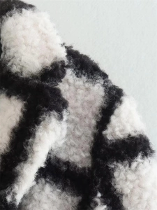 Close-up of the soft black and white checkered faux fur fabric texture for winter coat