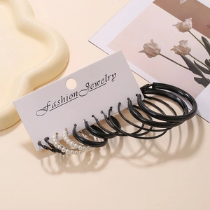 Detailed set of six pairs of black hoop earrings and pearl studs on fashion card board