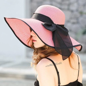 Pink wide-brim straw sun hat with elegant black mesh bow and ribbon for summer beachwear