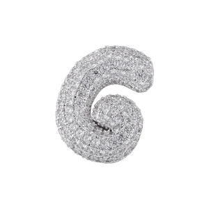 Macro shot of silver-colored letter G pendant with cubic zirconia pavé setting on white background