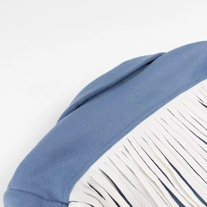 Detail shot of the blue wool blazer featuring delicate white fringe tassels and soft suede fabric