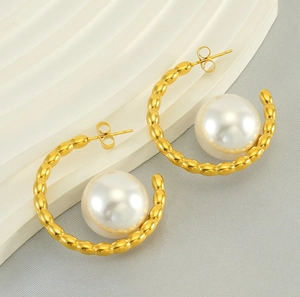 Detail of C-shaped gold-plated stainless steel earrings with large white round pearls