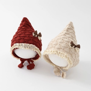 Knitted infant earflap hat with fish scale pattern, lace trim and bow in red and beige