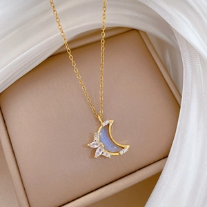 Close-up of crescent moon necklace with blue stone inlay and sparkling cubic zirconia
