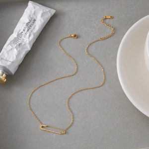 Dettaglio macro della collana a graffetta in acciaio inossidabile oro 18K con cristalli
