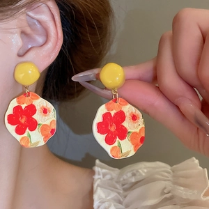 Detailed view of silver needle sunflower earrings with artistic oil painting textures