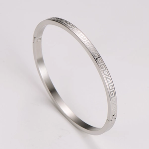 Detailed view of silver stainless steel bangle with classic Greek key geometric patterns