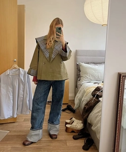 Vue détaillée d'une veste à revers à carreaux vert olive et d'un jean large sur un mannequin