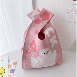 Detailed knit texture of pink wrist bag featuring cute white duck and floral patterns