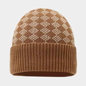 Detailed close-up of brown knit beanie with white geometric pattern and folded cuff