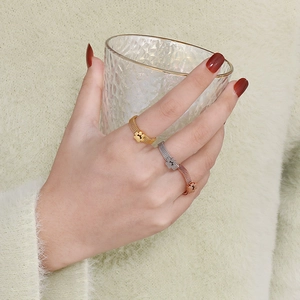 Detailed view of mesh band rings with cat paw charms in gold, silver, and rose gold finishes