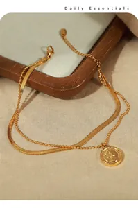 Close-up of dual-layer gold anklet with snake chain, bead chain and relief coin pendant
