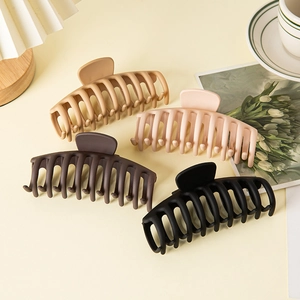 Macro shot of large matte hair claws in beige, pink, brown and black colors