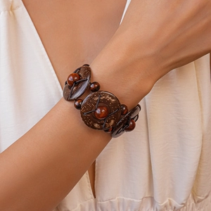 Détail d'un bracelet élastique à plusieurs rangs en perles de bois et coco