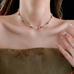 Colorful crystal beaded necklace featuring light blue and red beads on a female model