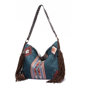 Close-up of ethnic geometric pattern and long suede tassels on boho tote bag