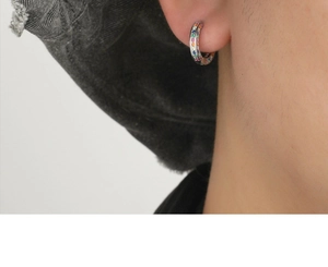 Macro close-up of rainbow cubic zirconia hoop earrings worn on ear with silver base