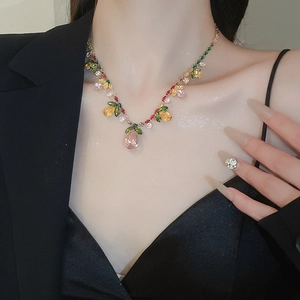 Detailed close-up of zircon floral necklace with multi-color teardrop gems on a model