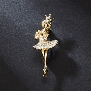 Detail of elegant gold ballet dancer brooch with sparkling rhinestones on black texture