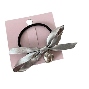 Silver bow hair scrunchie with heart pendant and elastic band on pink card