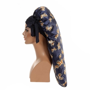 Detail of blue satin bonnet with gold butterfly prints and long adjustable ribbons