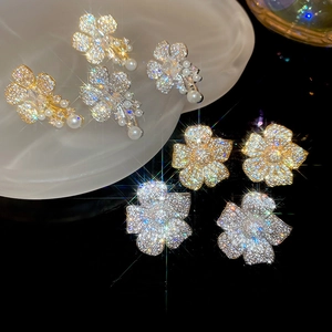 Detailed macro view of zircon flower earrings with pearls and a sparkling star effect
