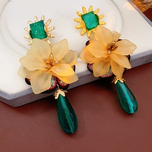 Macro detail of vintage floral earrings with green teardrop pendants and yellow flowers