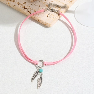 Detail of pink double-layer choker with silver feather charms and turquoise bead decoration