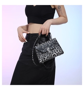 Close-up of stylish leopard print handbag with silver buckle and thin shoulder strap