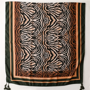 Detail of zebra pattern silk scarf with colorful print and fringe corners in close-up