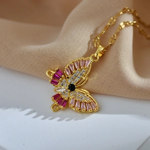 Elegant gold butterfly necklace with colorful zircon stones on soft beige fabric