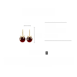 Détail de boucles d'oreilles cerises rouges avec nœud doré et zircon taille 2cm x 4,5cm