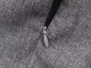 Detailed close-up of invisible zipper and grey melange textured fabric on midi skirt